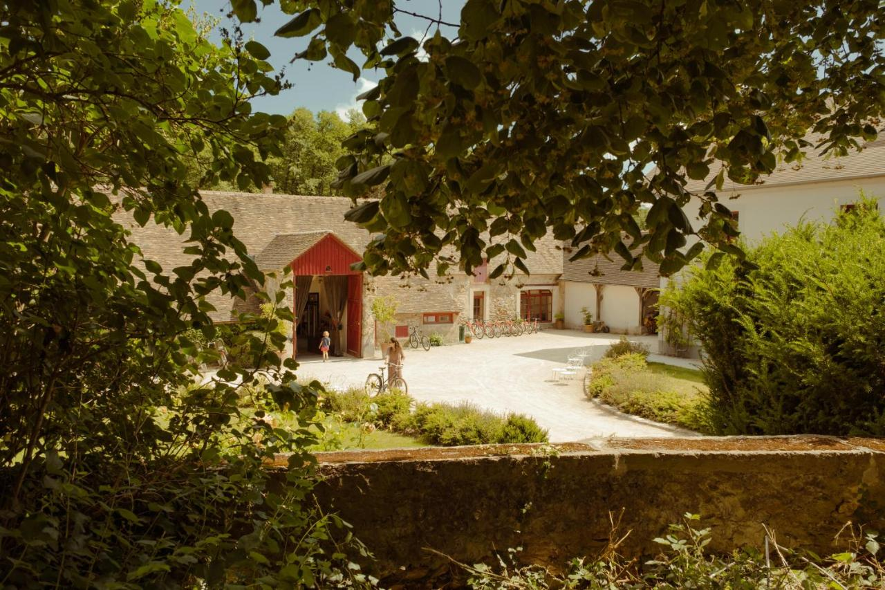 Le Barn France French farmhouse courtyard with red barn door, bicycles, stone walls, Loire Valley