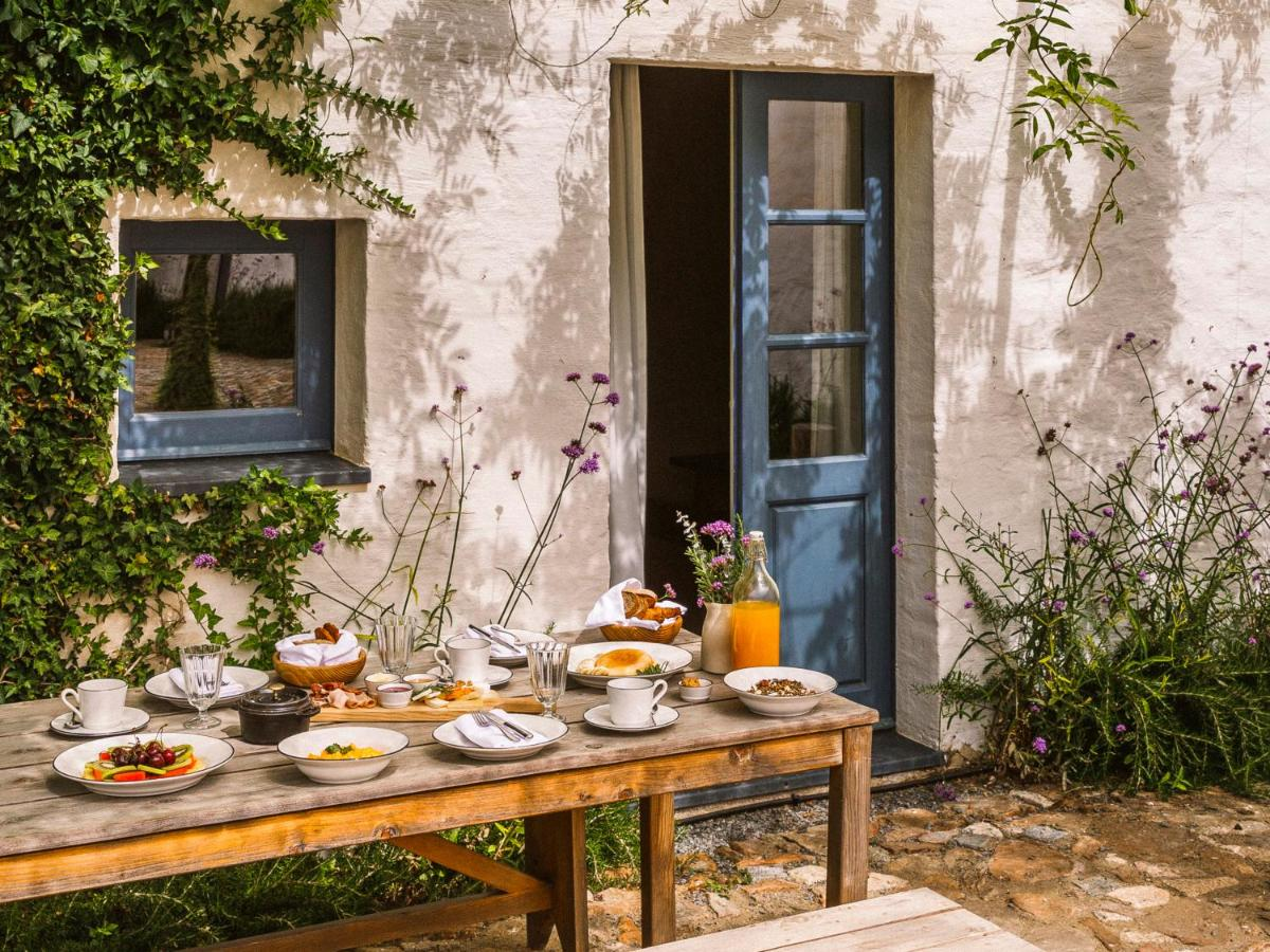 São Lourenço do Barrocal Portugal rustic whitewashed farmhouse with blue door and outdoor breakfast table, Alentejo