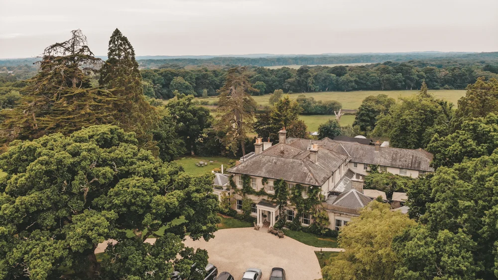 The Pig at Brockenhurst English country house aerial view surrounded by mature trees, New Forest
