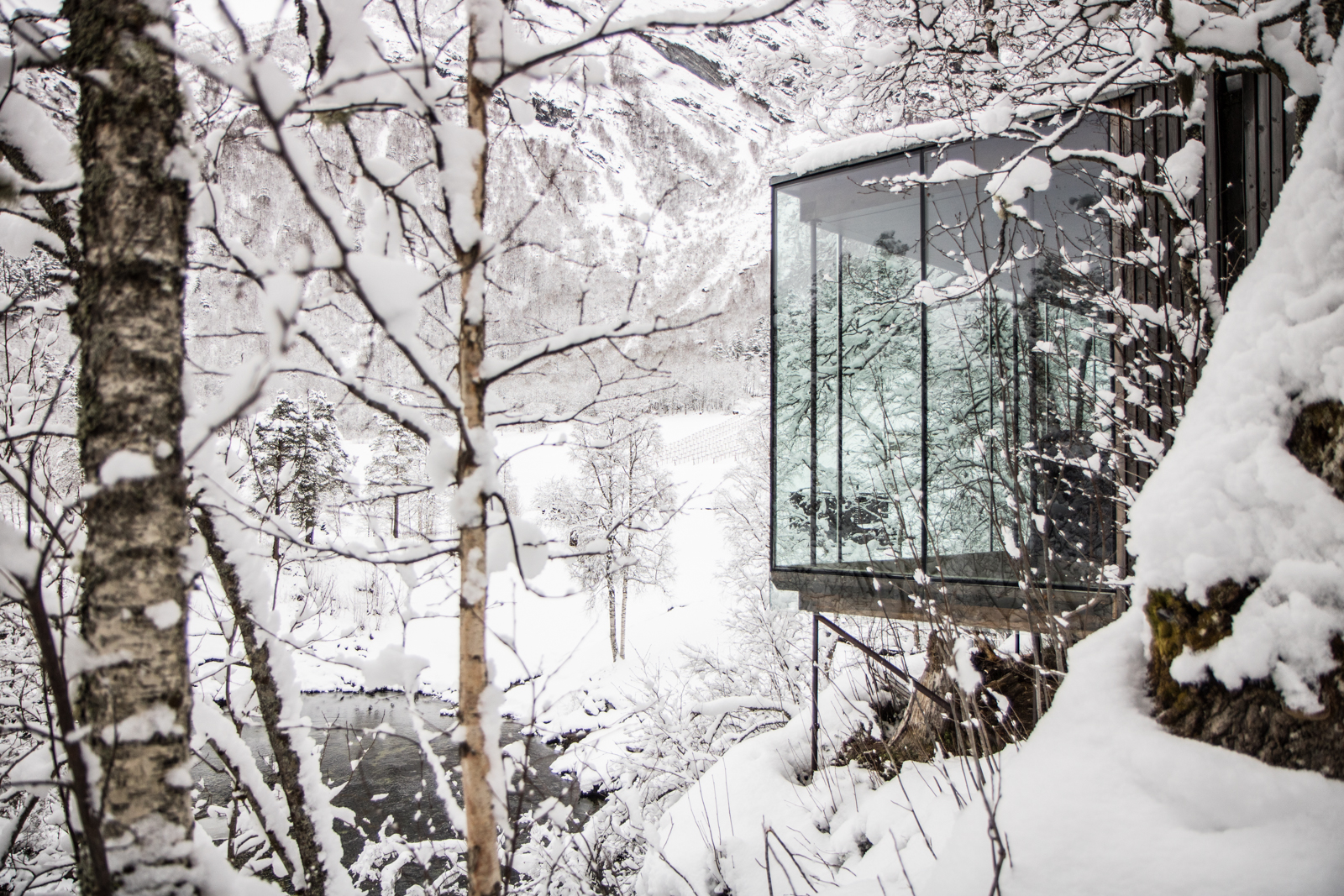 Juvet Landscape Hotel glass-walled room cantilevered over snowy Norwegian valley