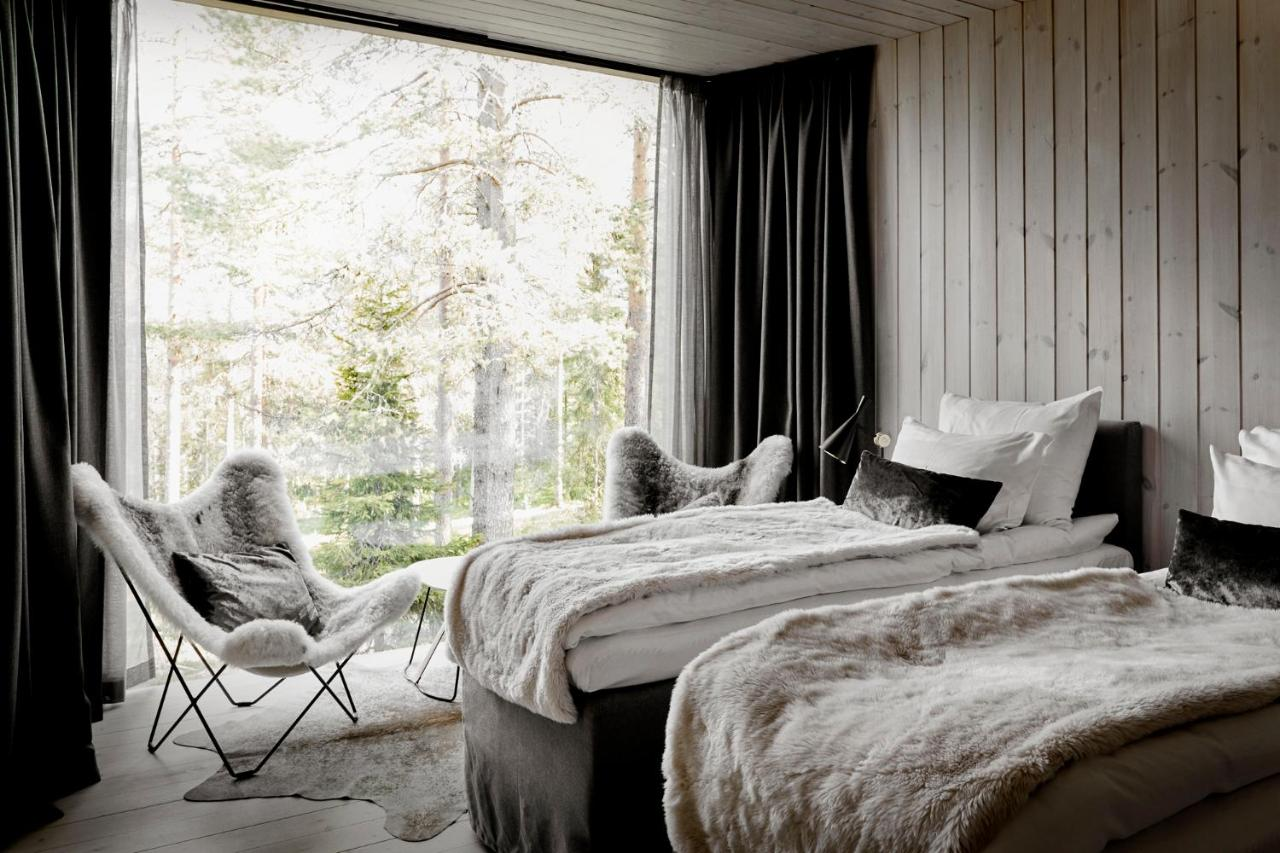 Arctic TreeHouse Hotel Finland bedroom with fur throws and forest view