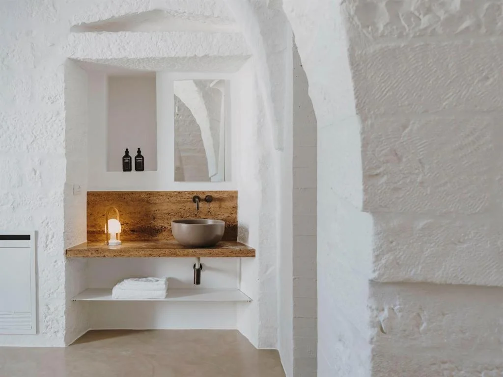 Minimalist suite with stone floors and olive grove views at Masseria Dagilupi