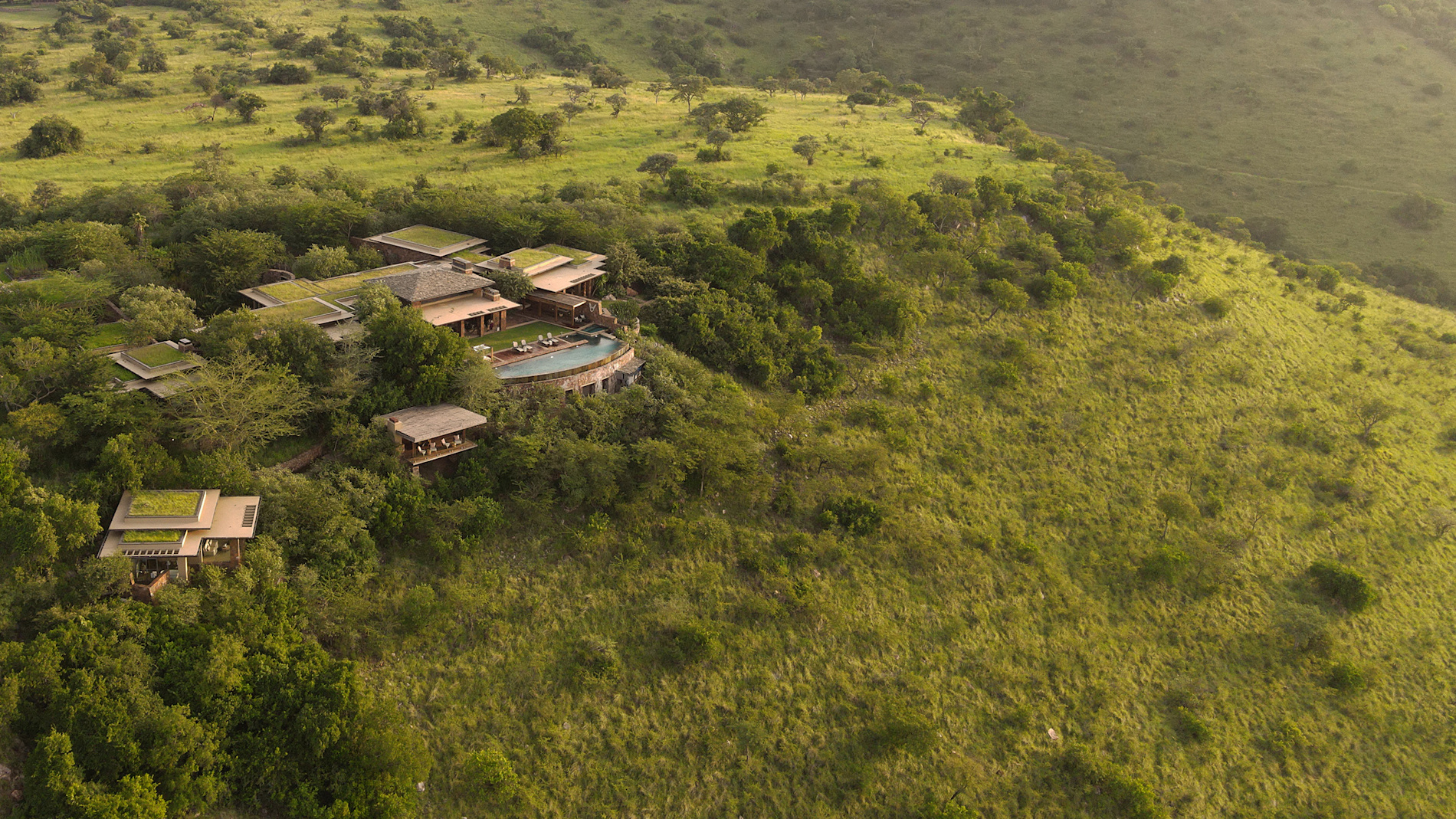 Singita Kilima Kenya aerial view of luxury lodge on hillside in green savannah with infinity pool