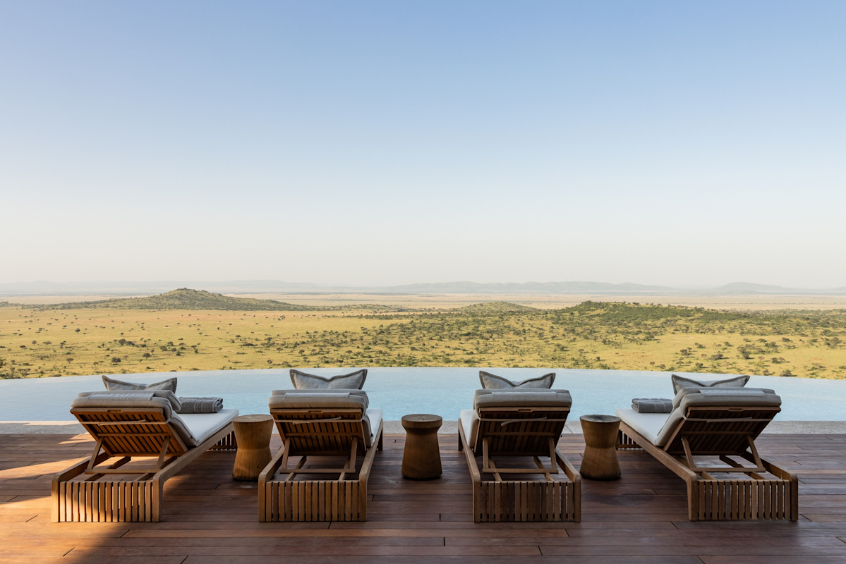 Singita Milele Kenya infinity pool overlooking vast Serengeti plains with teak sun loungers