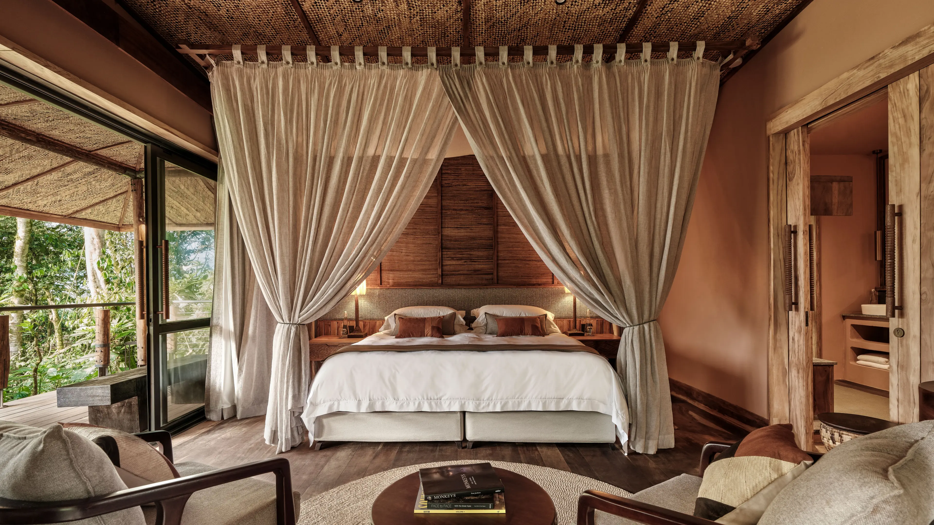 Gorilla Forest Lodge Uganda luxurious forest villa bedroom with canopy drapes, bamboo ceiling, jungle view