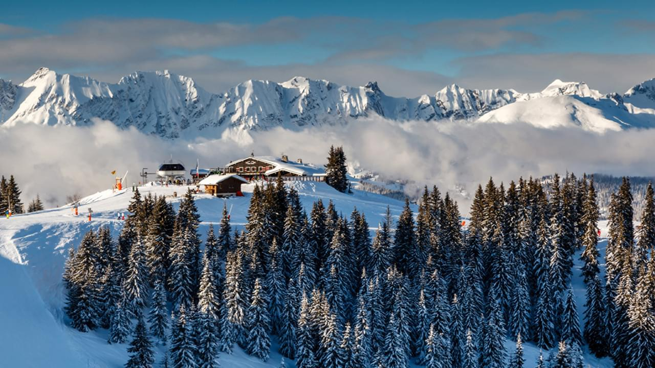 Fäern Arosa Switzerland aerial view of Alpine resort on snowy hillside above forest